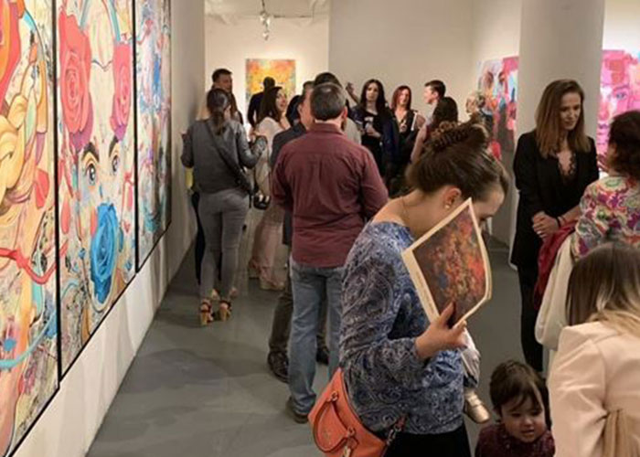 Photo of the gallery with crowds of people during an exhibit. Photo of the gallery with crowds of people during an exhibit.